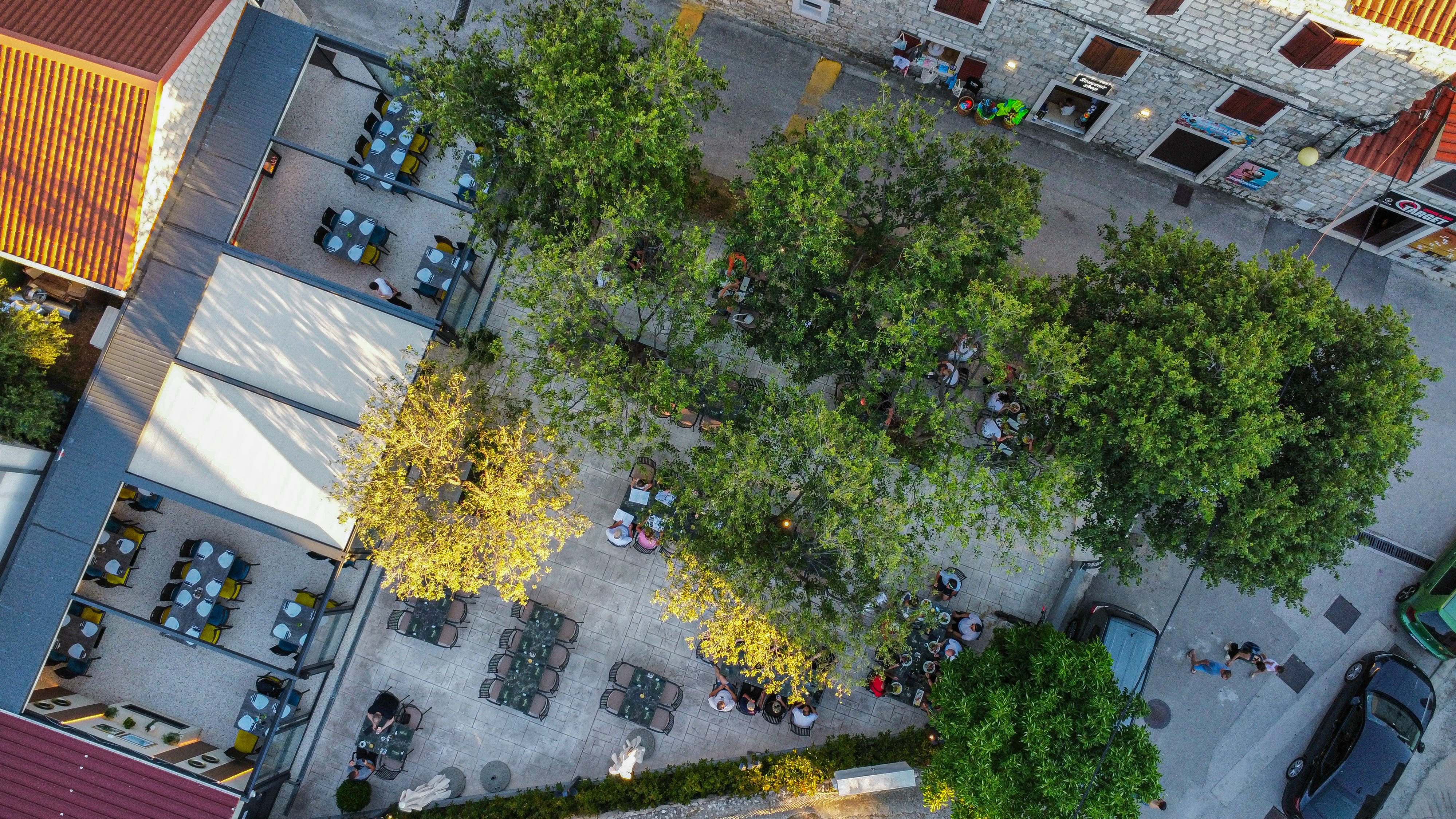 Aerial view of Strada's tree-lined courtyard and outdoor tables