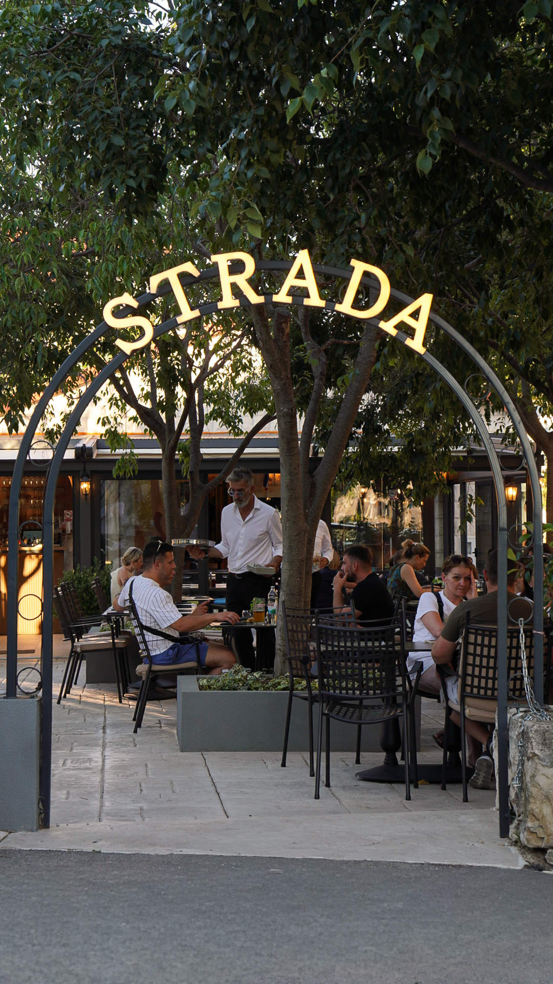 Guests dining beneath the Strada courtyard archway